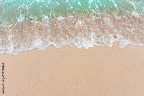 Summer beach concept - Soft wave of sea on empty sandy beach Background with copy space. © Achira22