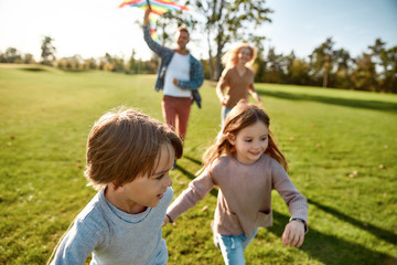 Children are living jewels. Happy family playing a kite. Outdoor family weekend