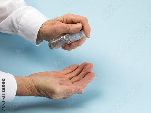 washing hands with hand sanitizer sometimes used for protection from viruses such as Novel Coronavirus (2019-nCoV) on a blue background