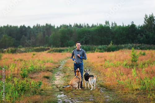 Calm young man walking with dogs at nature
