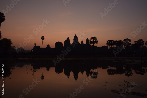 orange sunrise over famous angkor wat temple with lake and reflection in the water with lillypad