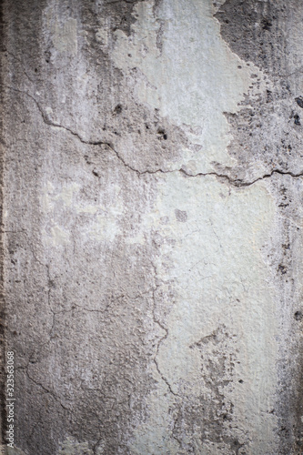 A cracked cement wall with peeling paint