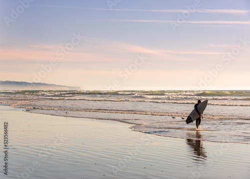 Surfer on the shore of the famous Pismo beach in California.