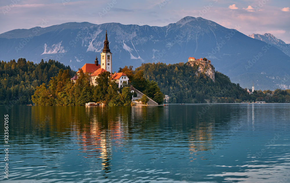 The enchanting church on the small island on Lake Bled in Slovenia, in the background the magnificent castle.
