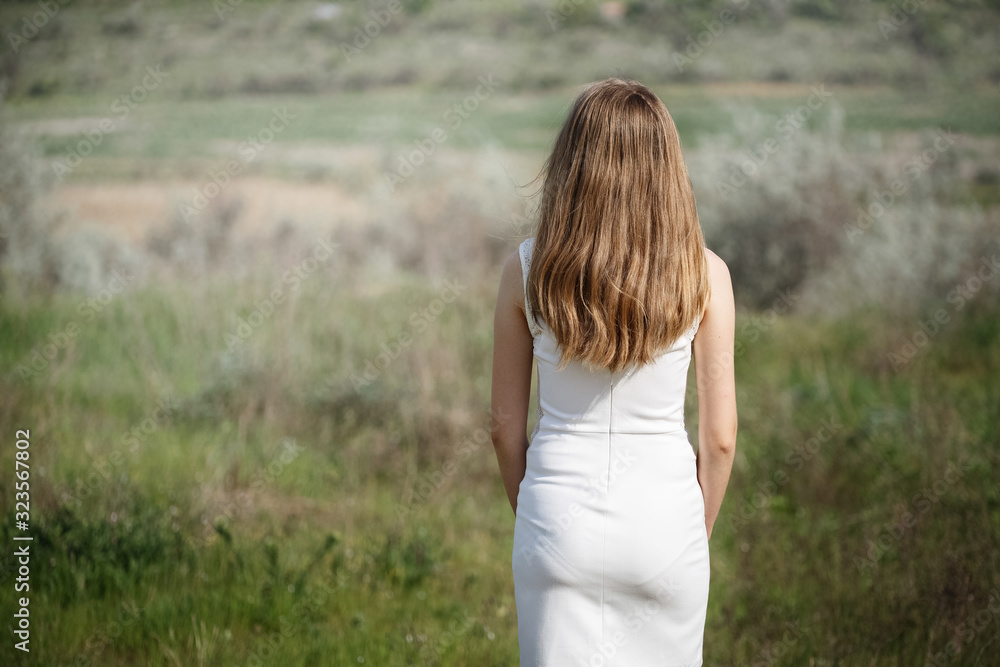 girl standing with her back in the field girl standing with her back in the field