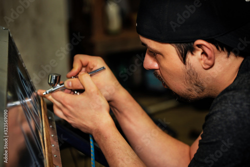 man painting in the details with air brush