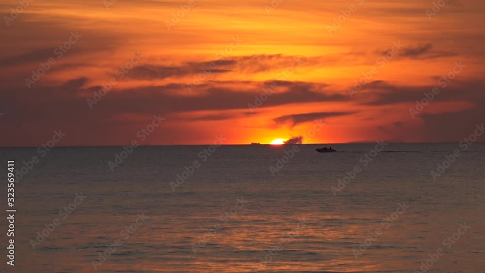 The boat floats on the ocean against the backdrop of a beautiful sunset, the contour of the boat on an orange sky. The boat floats on the ocean against the backdrop of a beautiful sunset, the contour of the boat on an orange sky.