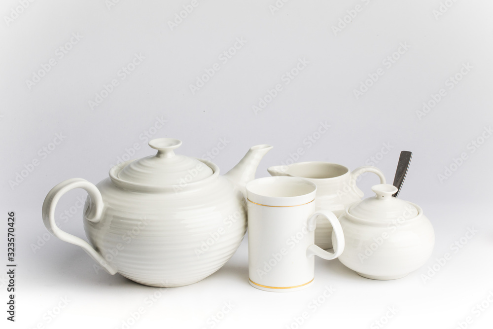 a white ceramic teapot sugar and cream set on a wooden table top a white ceramic teapot sugar and cream set on a wooden table top