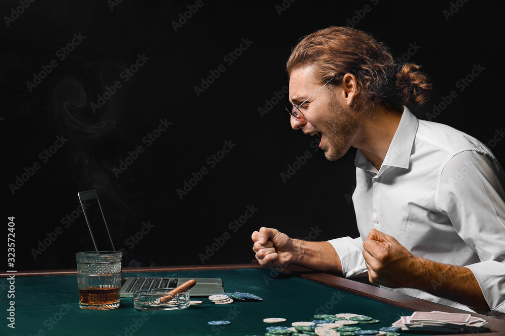 Emotional young man playing poker online Emotional young man playing poker online