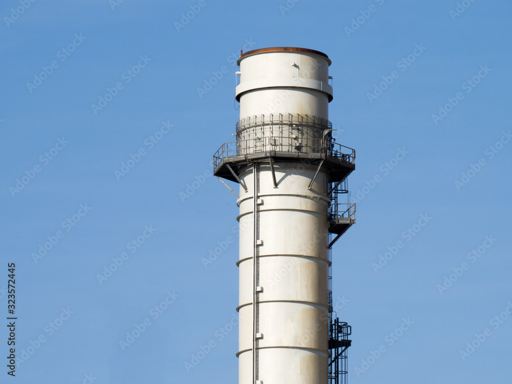 a tall industrial smoke stack on a blue sky a tall industrial smoke stack on a blue sky