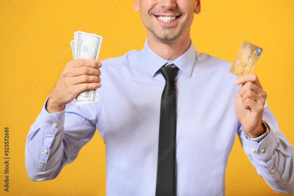 Male bank manager with credit card and money on color background Male bank manager with credit card and money on color background
