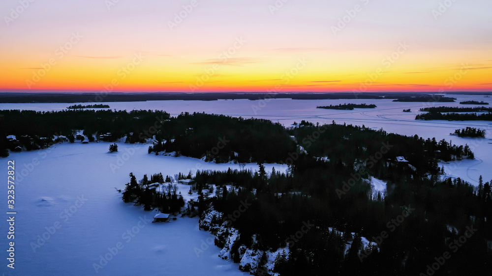Sunset over the frozen winter horizon of Ontario's Lake of The Woods.