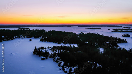 Sunset over the frozen winter horizon of Ontario's Lake of The Woods.