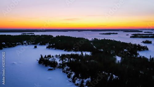 Sunset over the frozen winter horizon of Ontario's Lake of The Woods. photo