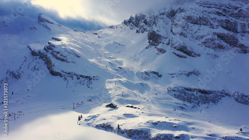 Beautiful sunny winterÂ´s day in the alps with snow capped mountains - aerial drone footage - aerial photography photo