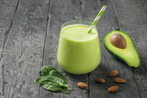 A glass with a smoothie made from almond milk, avocado and spinach. Fitness product.