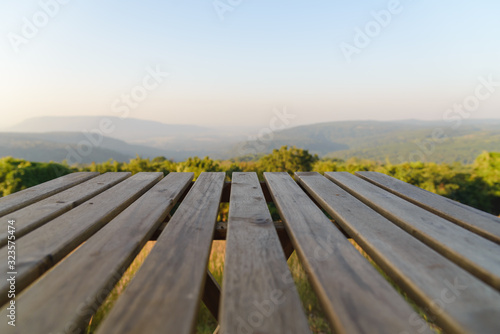 Empty wooden table top in front of trees and mountain landscape, For product display or montage your products.