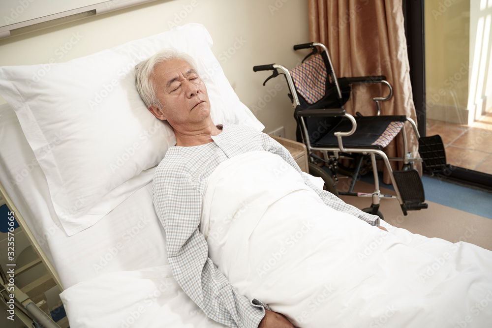 Obraz premium asian old man lying in hosptial bed eyes closed