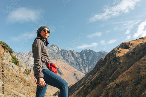 Woman tourist hiker travel through mountains trails.