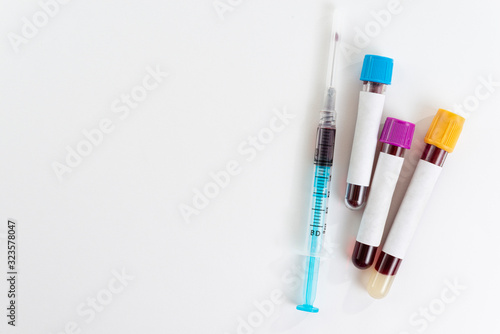 Test tubes with blood isolated and syringe on white.
