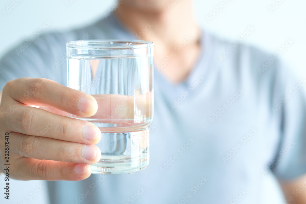 In the Morning, hand of man holding a clear glass of water for drinking. In the Morning, hand of man holding a clear glass of water for drinking.