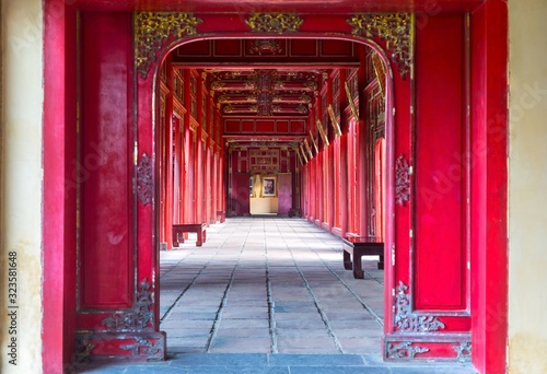 Symmetrical Corridor and Red Doors in the Forbidden Purple City, Historic Imperial Palace Hue Vietnam, United Nations World Heritage Site #323581648