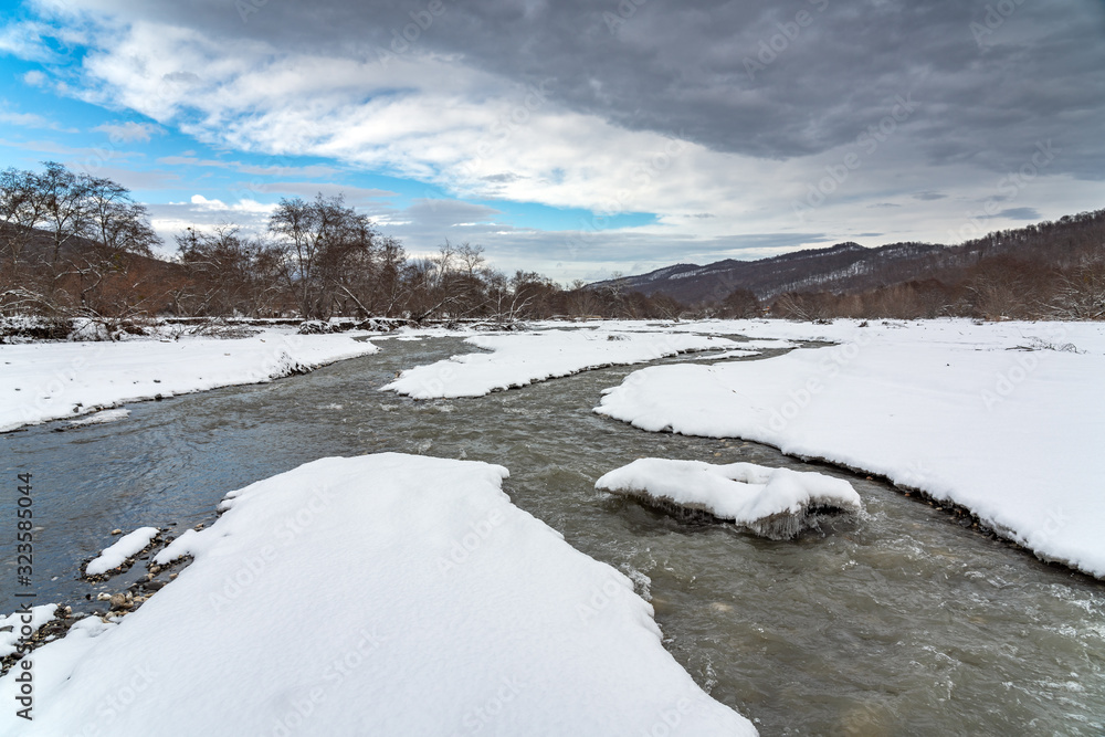 Fast mountain river stream in winter season Fast mountain river stream in winter season