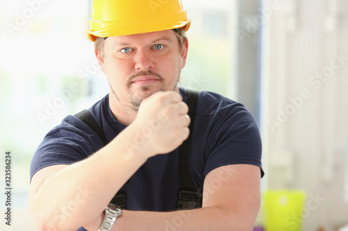 Smiling funny worker in yellow helmet posing. Manual job workplace DIY inspiration improvement fix shop hard hat joinery startup idea industrial education profession career concept
