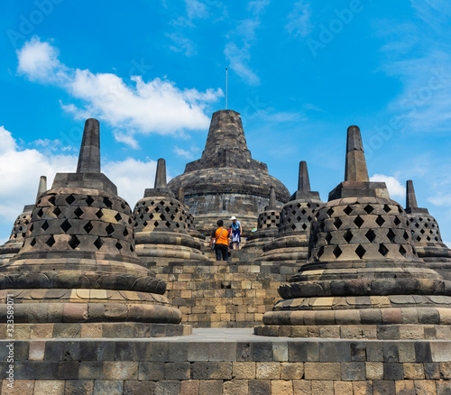 Magelang, Indonesia - CIRCA July 2017: Several stupas with tourists in Borobudur Temple, Indonesia. It is going to be the center for Vesak Day celebration in Indonesia.