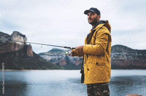 Canvas Print fishery concept, beard fisherman hold in hands fishing rod, man enjoy hobby spor