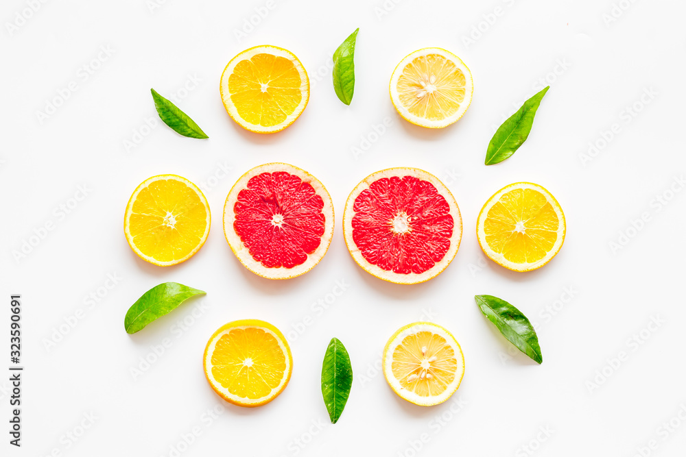 Citrus pattern. Lemon and grapefruits slices and leaves on white background top-down