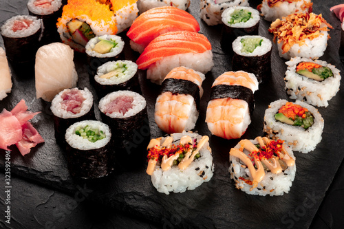 Large sushi set on a black background. Many different maki, nigiri and rolls