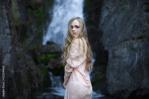 Girl on the background of a waterfall