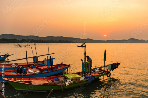 Chanthaburi, Thailand - February, 02, 2020 :Beautiful sunrise over sea with Silhouette of fishermen with yellow and orange sun in the background.