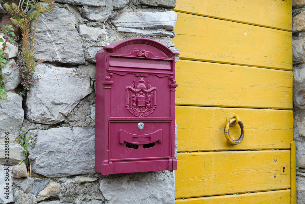 Vintage postbox on the stone wall near the door in the Italian town Porto Venere