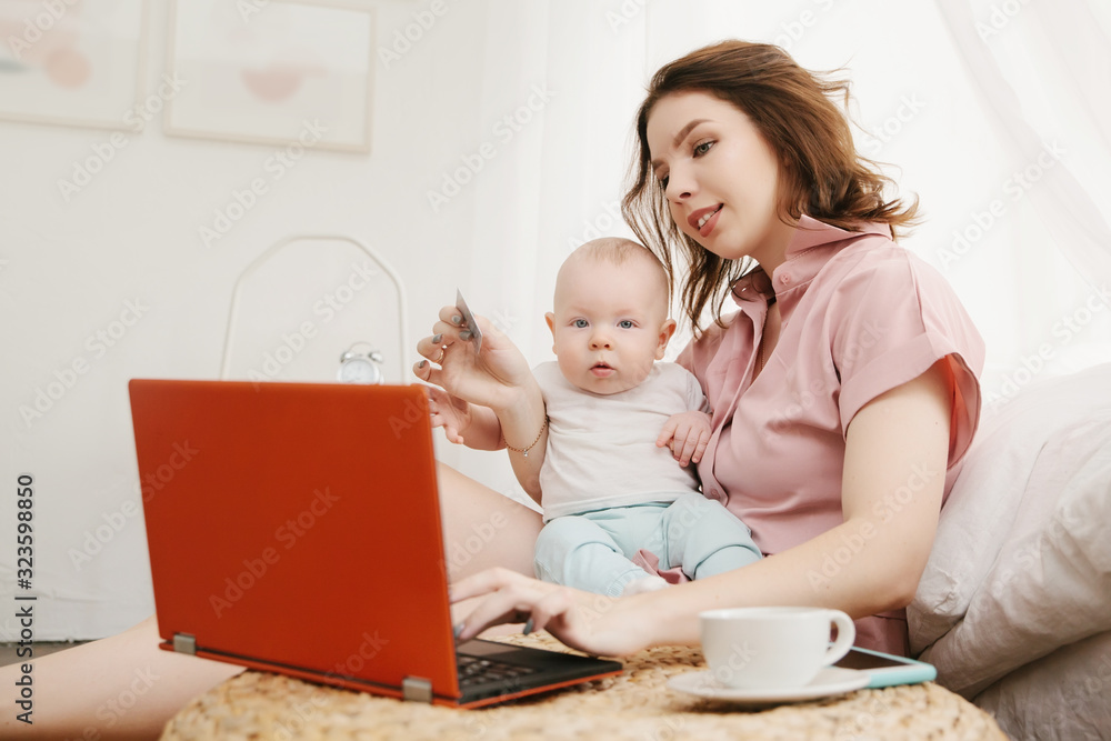 portrait of mother and little son doing online shopping with credit card, using laptop. portrait of mother and little son doing online shopping with credit card, using laptop.