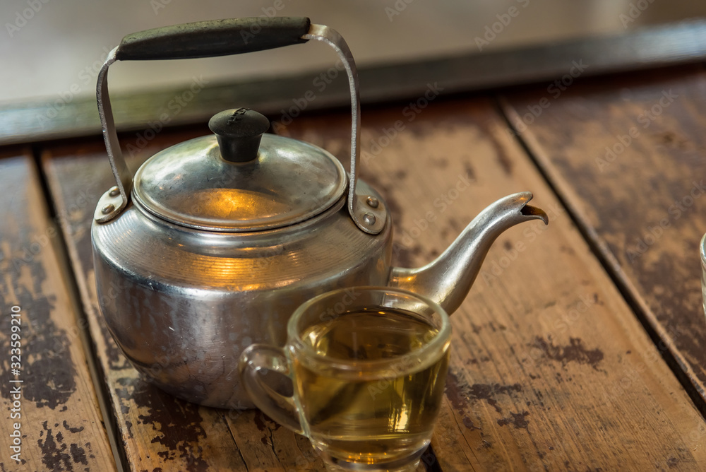 Teapot and cup of tea on the wooden background.