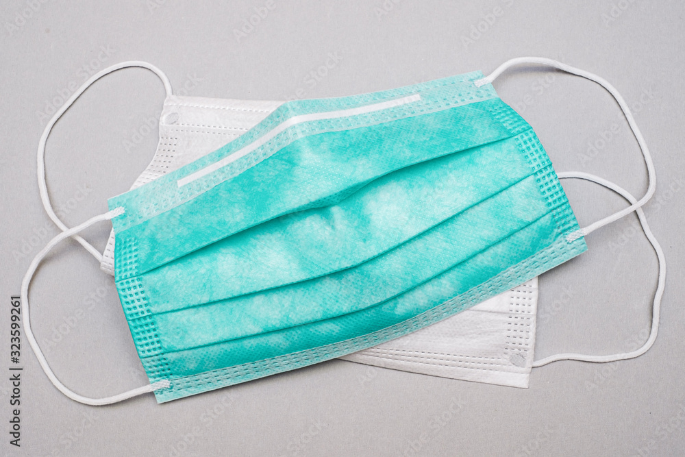 Surgical mask with rubber earband. A typical three-layer surgical mask covering the nose and mouth. Surgical mask with rubber earband. A typical three-layer surgical mask covering the nose and mouth.