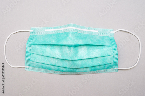 Surgical mask with rubber earband. A typical three-layer surgical mask covering the nose and mouth.