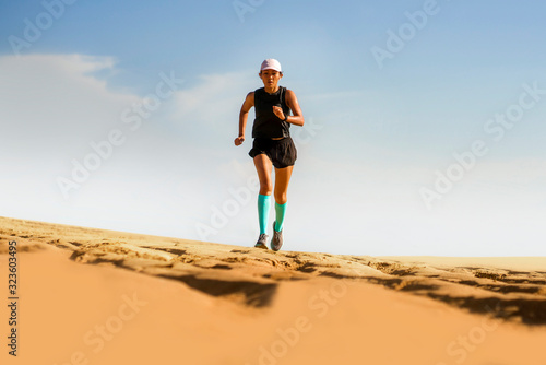 outdoors fitness lifestyle portrait of young attractive and athletic Asian woman in compression running socks on the beach doing jogging workout in sport training