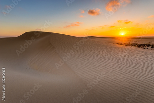 Sand dunes in the National Park of Dunas de Corralejo during a beautiful sunrise- Canary Islands - Fuerteventura. photo