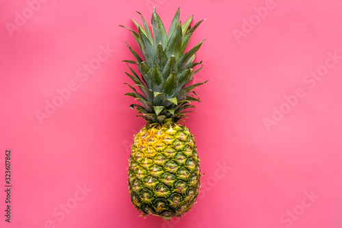 Pineapple - whole fruit - on bright pink background top-down copy space
