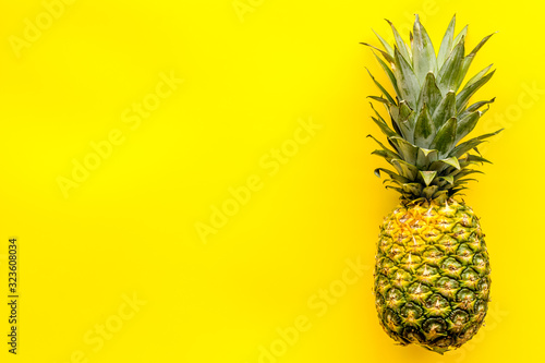 Pineapple - whole fruit - on bright yellow background top-down copy space