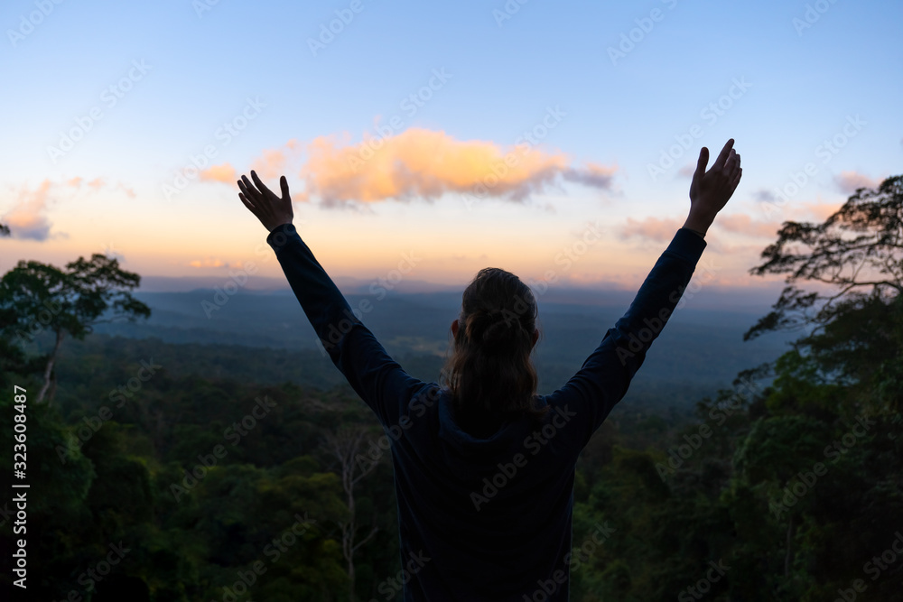 Picture of silhouette woman raising arms on hill at sunrise - obrazy, fototapety, plakaty 