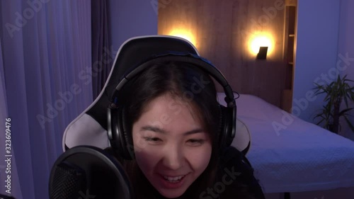 POV webcam view, Korean female gamer streamer winning a game while streaming online game from home. 4K UHD RAW graded footage photo