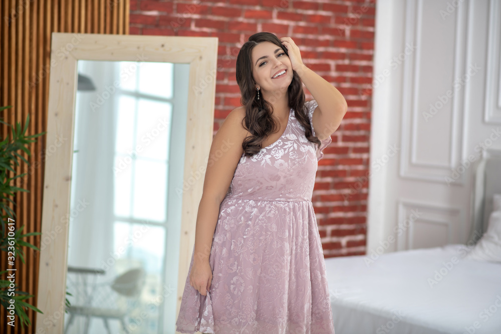 Young plus-size woman in a pink dress feeling great