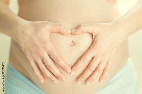 Wallpaper Mural Pregnant woman making heart shape with her hands Torontodigital.ca