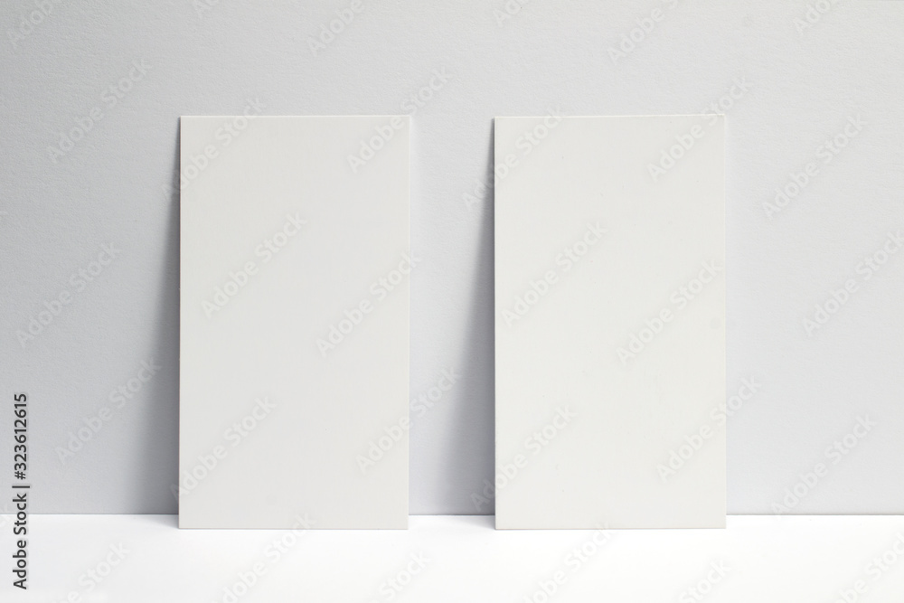 2 blank business cards locked on white wall, 3.5 x 2 inches size as template for design presentation, showcase et