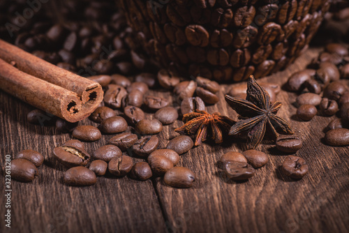 Coffee Beans Cinnamon Stick Anise Star Wooden Table Close-up. Background for coffee beans in dark colors for the background.