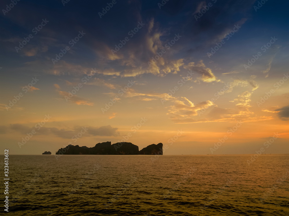 Sea view evening of Phi Phi Leh island in the sea with yellow sun light and blue sky background, sunset at Phi Phi Don island, Krabi, southern of Thailand.